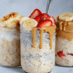 Three jars of overnight oats with chia seeds, topped with bananas, strawberries, and peanut butter
