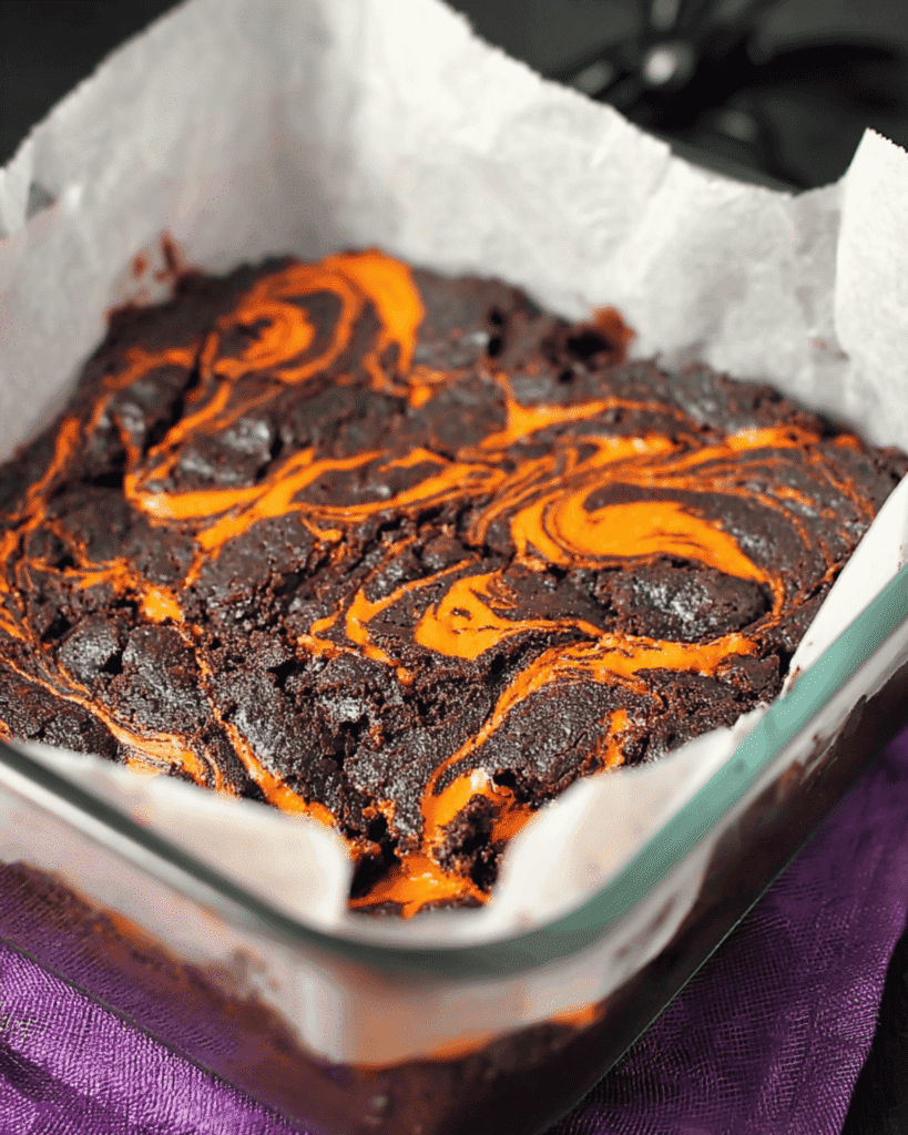Halloween swirl brownies in a glass baking dish lined with parchment paper
