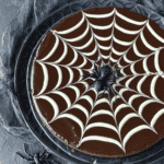 Overhead view of Chocolate Spiderweb Cheesecake with dark ganache and white chocolate spiderweb