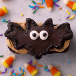 Halloween bat wing chocolate pretzel mix cookie with peanut butter filling, candy eyes, candy corn, and colorful sprinkles.