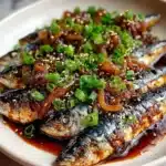 Plate of Smoky Mackerel Bulgogi topped with onions, scallions, and sesame seeds
