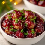 Quick Cranberry Meatballs served in a white bowl with rich cranberry sauce and parsley garnish for Christmas dinner.