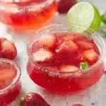 homemade strawberry gelatin dessert with fresh strawberry slices and lime accents on white cloth