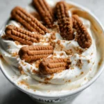 Close-up of whipped yogurt with Lotus Biscoff cookies and crushed cookie crumbs sprinkled on top for texture.