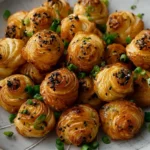 Freshly baked Scallion Pancake Croissants arranged on a white ceramic plate with chopped green onions and sesame seeds