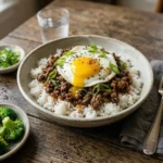 Boy Kibble Bowl : Rice bowl with ground beef and a fried egg with a runny yolk topped with sesame seeds and green onions