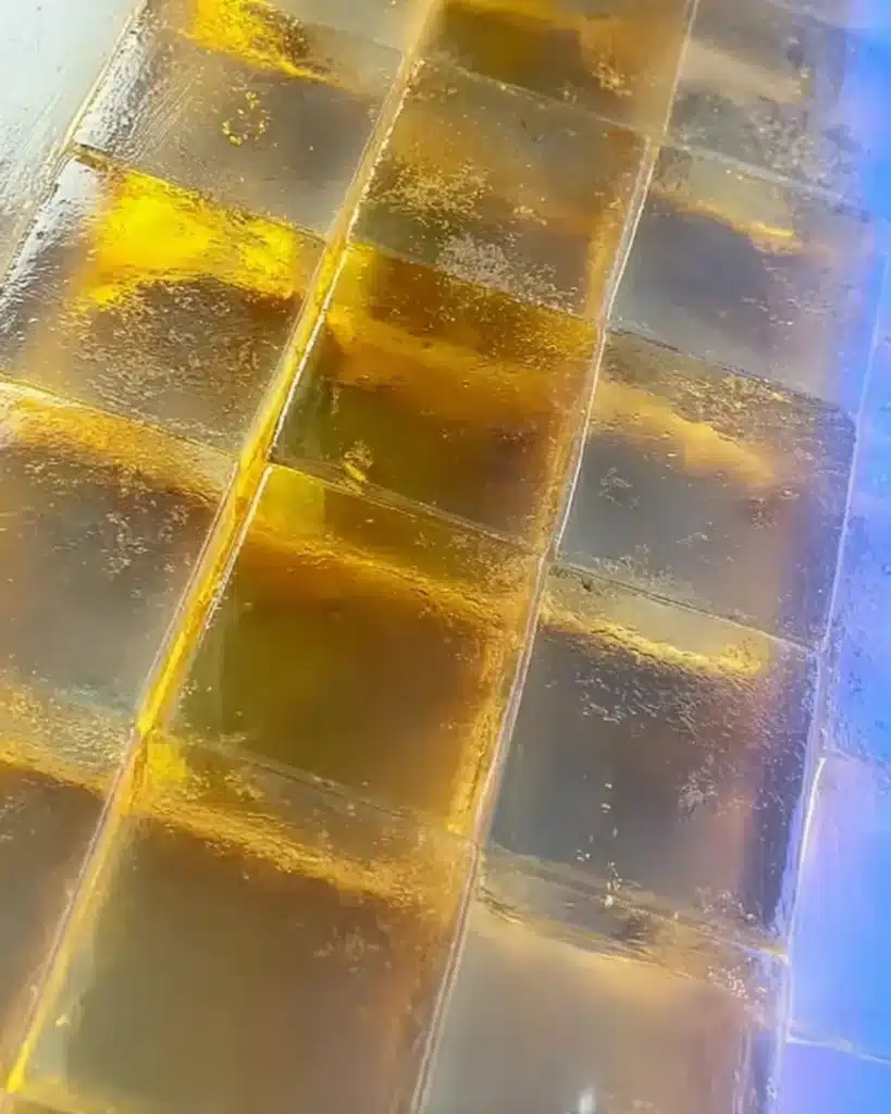 Close up of tea jelly cubes arranged in a neat grid inside a glass dish