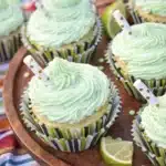 Margarita cupcakes with tequila lime buttercream frosting topped with decorative straw and fresh lime slice