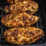 Juicy air fryer chicken breasts cooking in basket with crispy seasoned exterior and golden brown texture