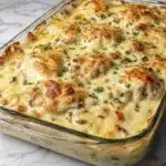 Creamy chicken bake in glass dish with golden melted cheese and mushrooms