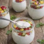 Creamy yogurt panna cotta in glass jars topped with fresh strawberries kiwi and mango fruit
