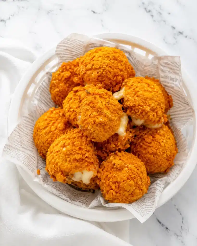 Crispy golden cheese bites served in a bowl lined with parchment paper