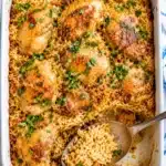 Served portion of chicken and rice on a beige plate with parsley garnish and fork on the side