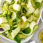Close view of zucchini ribbons with Parmesan, herbs, and pine nuts