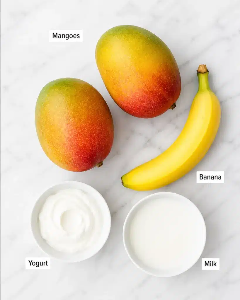Fresh mango smoothie banana yogurt and milk arranged on marble surface for smoothie ingredients