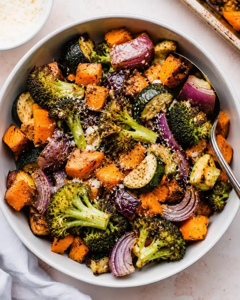 roasted vegetable bowl served with spoon and seasoning on top