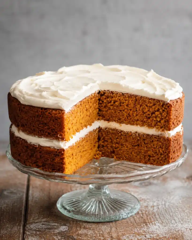 slice of moist spiced cake with cream frosting on a plate