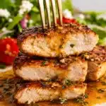 Stacked slices of chicken breast with fork showing tender inside and garlic sauce on top