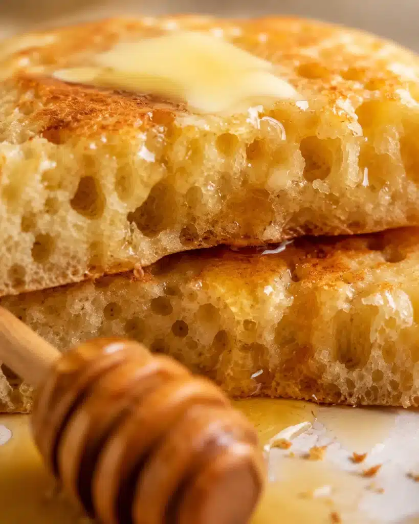 cut crumpet showing airy interior with honey soaking into the sponge-like texture