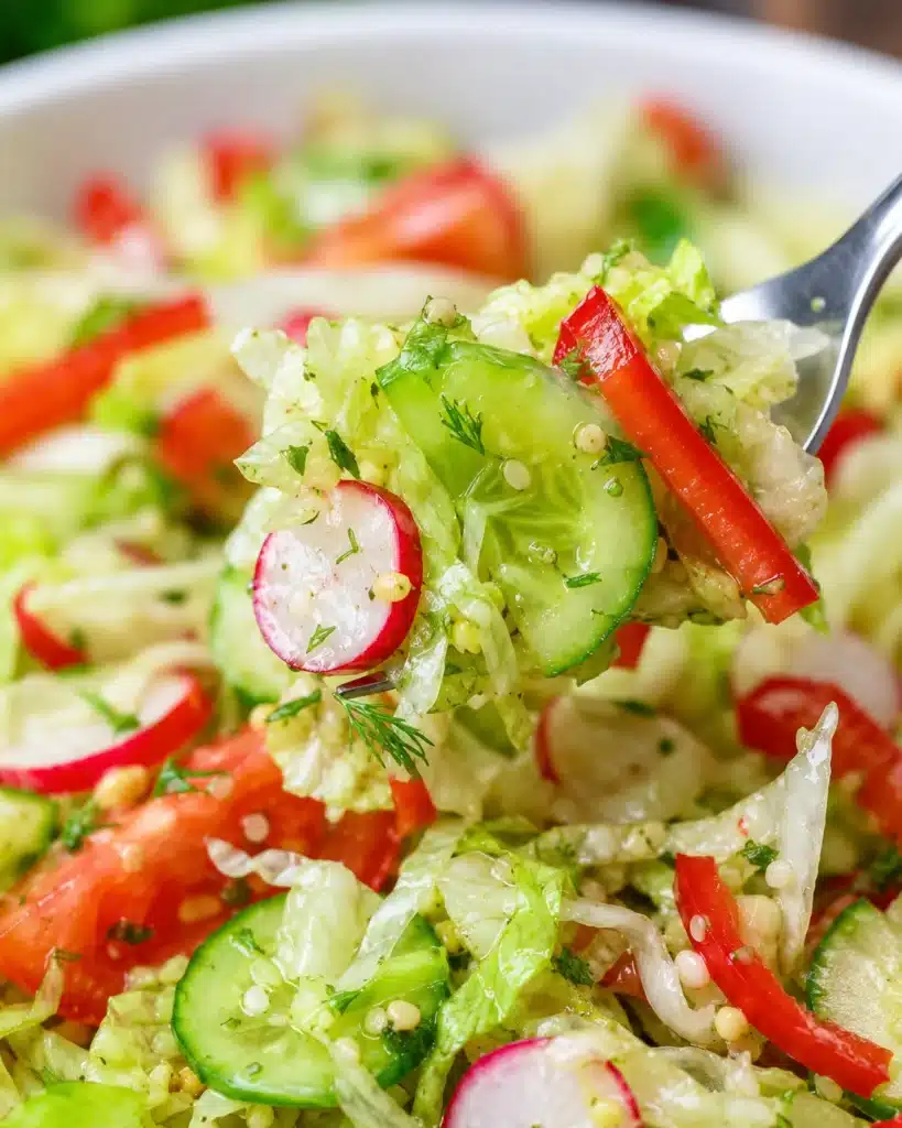 Bowl of fresh chopped lettuce with cucumbers, tomatoes, radishes, and herbs