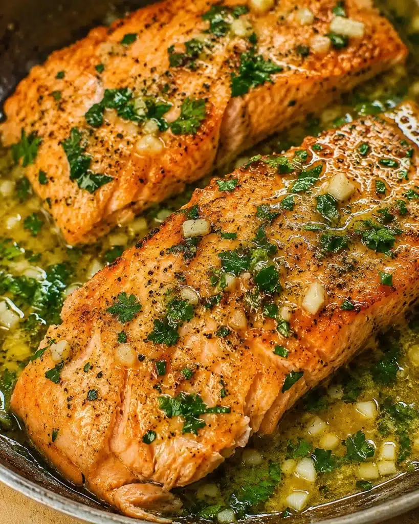 Pan seared trout fillets in a skillet with garlic, butter, and fresh herbs