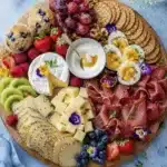 stylish breakfast platter with berries kiwi cheese eggs crackers and edible flowers