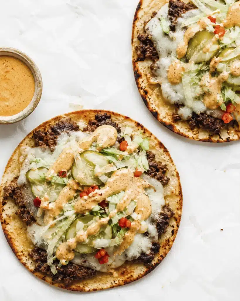 Top view smash burger tacos with cheese lettuce pickles and sauce served with dipping bowl