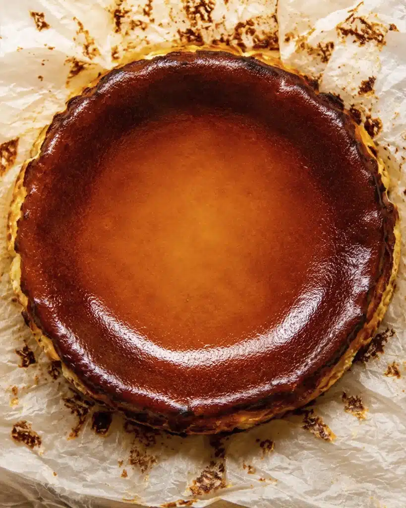 basque burnt cheesecake with a glossy caramelized surface on parchment paper