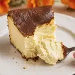 slice of basque burnt cheesecakewith a spoon lifting the creamy soft interior