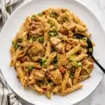 cajun chicken pasta sauce topped with green onions on a plate
